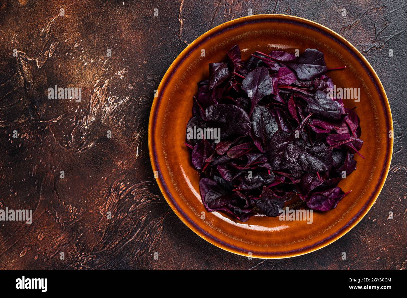 Raw Ruby or red chard salad Leafs on a rustic plate. Dark background. Top view. Copy space Stock Photo