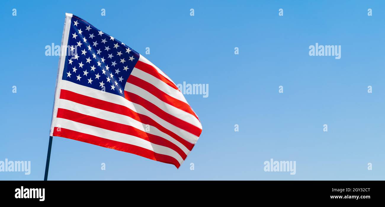 American flag waving in the wind against blue sky Stock Photo - Alamy