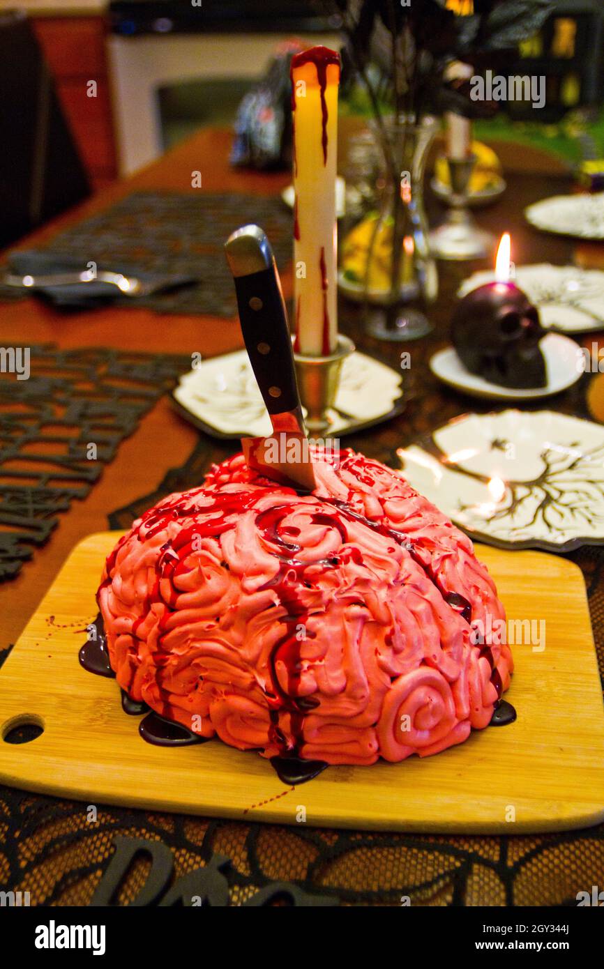 Realistic looking Halloween brain cake with blood red sauce and a knife stabbing the crease Stock Photo