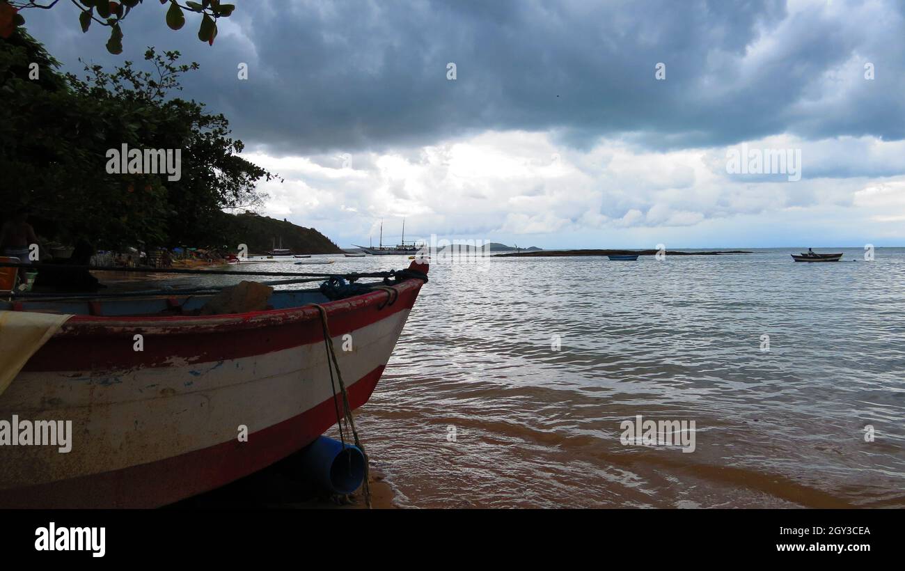 Anchored old fishing boat at the beach in a cloudly day Stock Photo