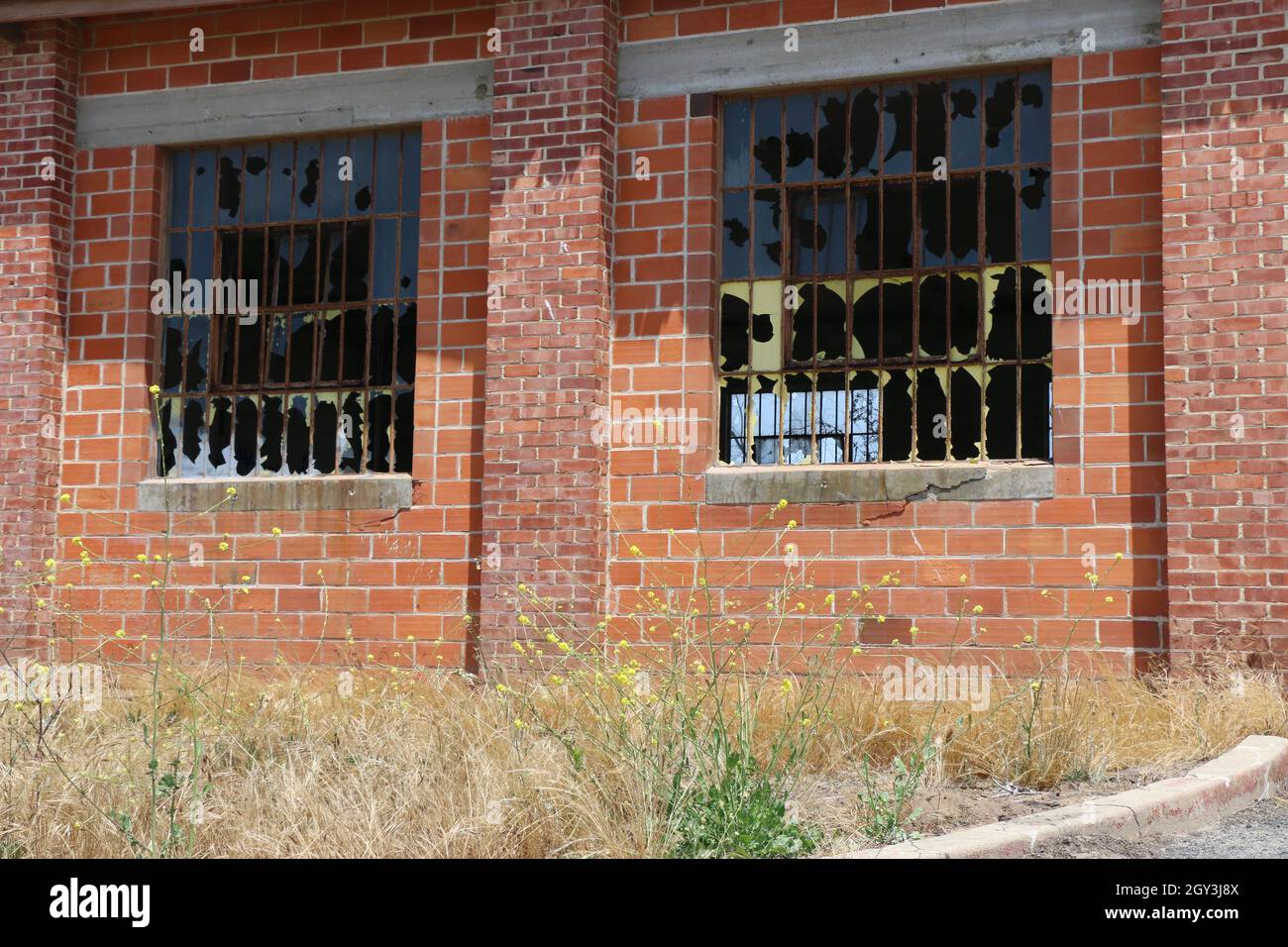Derelict, abandoned brick warehouse with smashed windows. Stock Photo