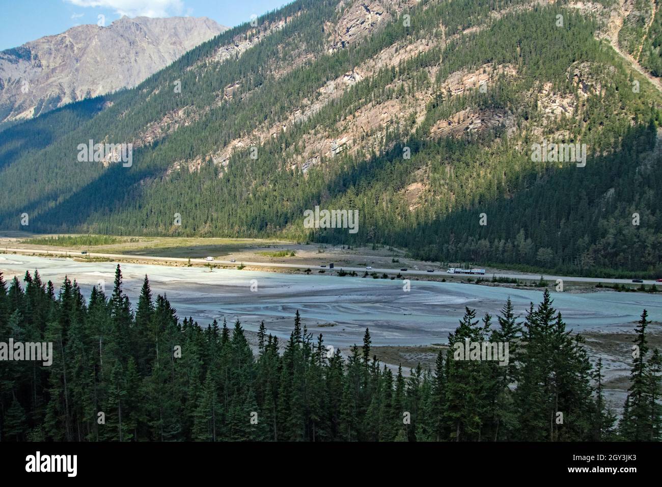 A view of a river below forested mountains Stock Photo - Alamy