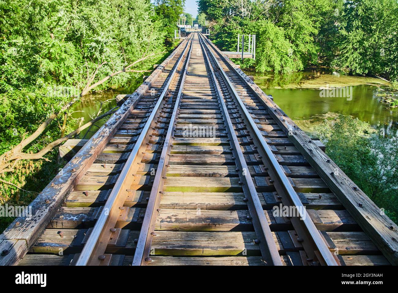 Wide view walking on railroad train tracks crossing over water Stock