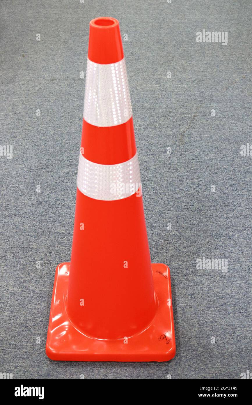 The orange traffic cone made of rubber is very useful as a sign on the highway Stock Photo