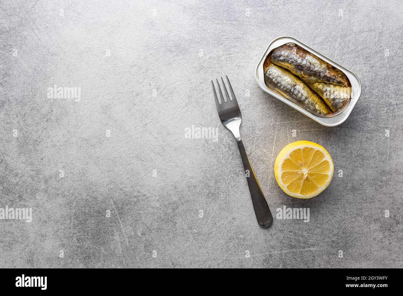Canned sardines. Sea fish in tin can on kitchen table. Top view Stock