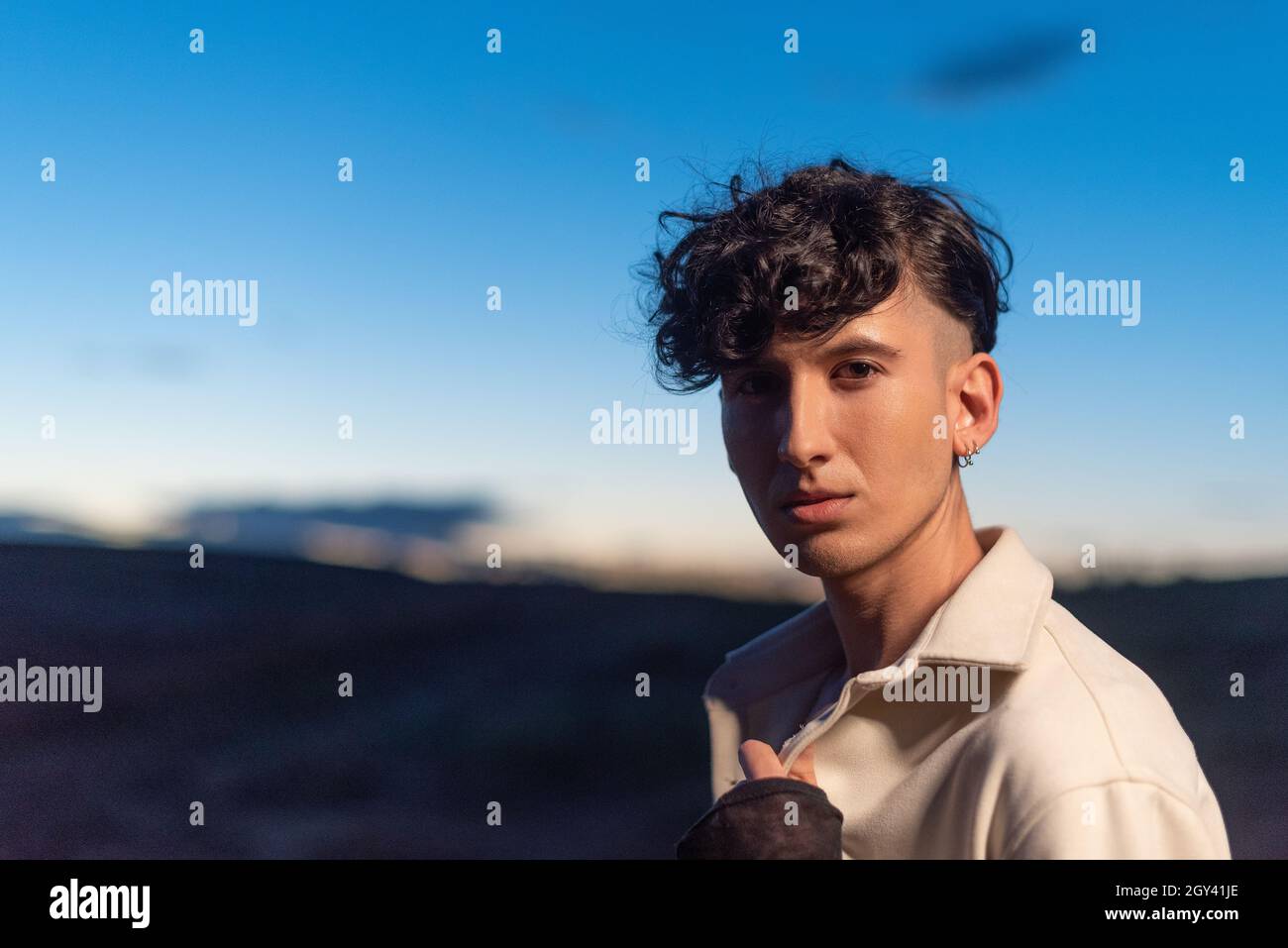 Non binary person facing the camera with relaxed expression Stock Photo