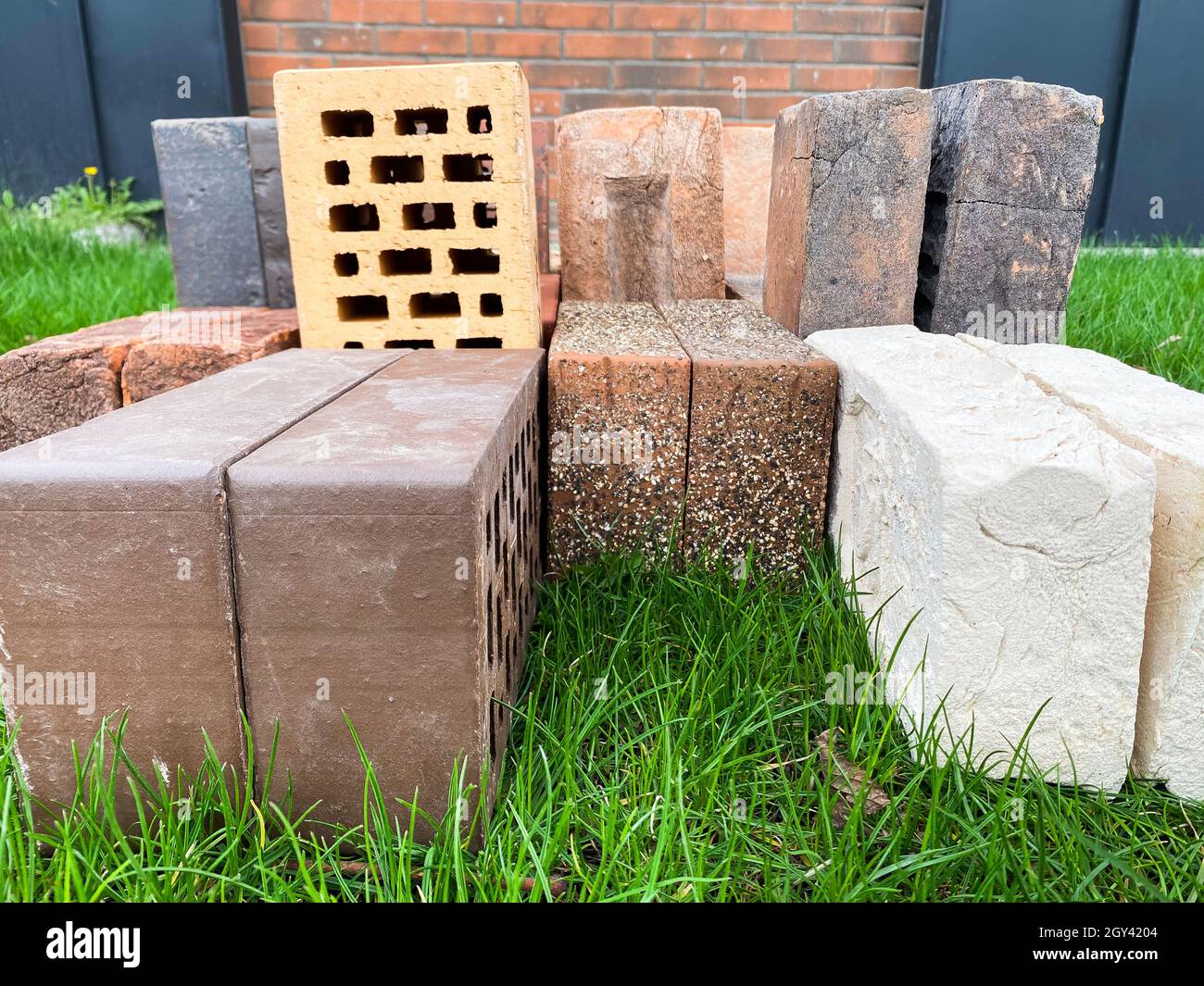Different types of bricks stacked beautifully on green grass Stock Photo