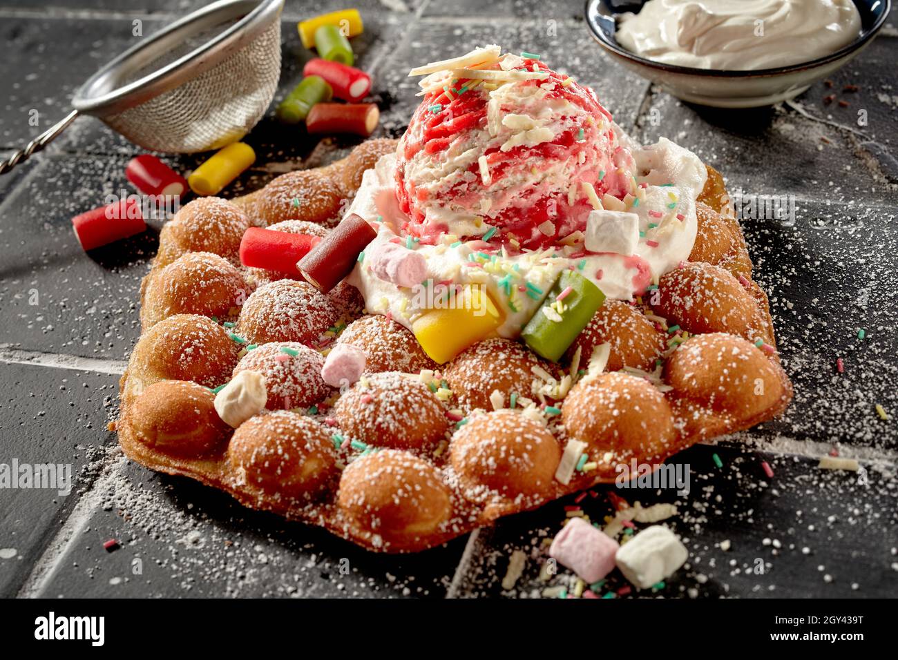 Party treat with bubble waffle and candy dessert topped with whipped
