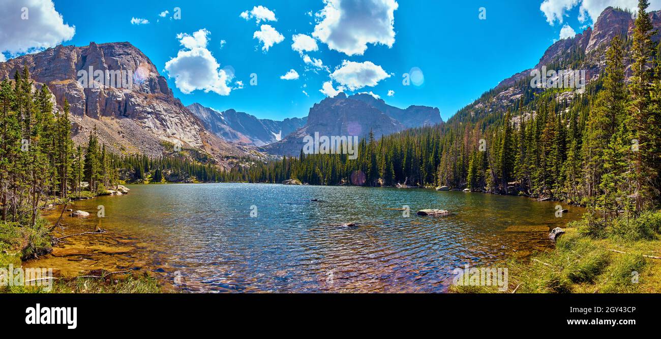 Beautiful isolated lake tucked into mountains surrounded by pine trees Stock Photo
