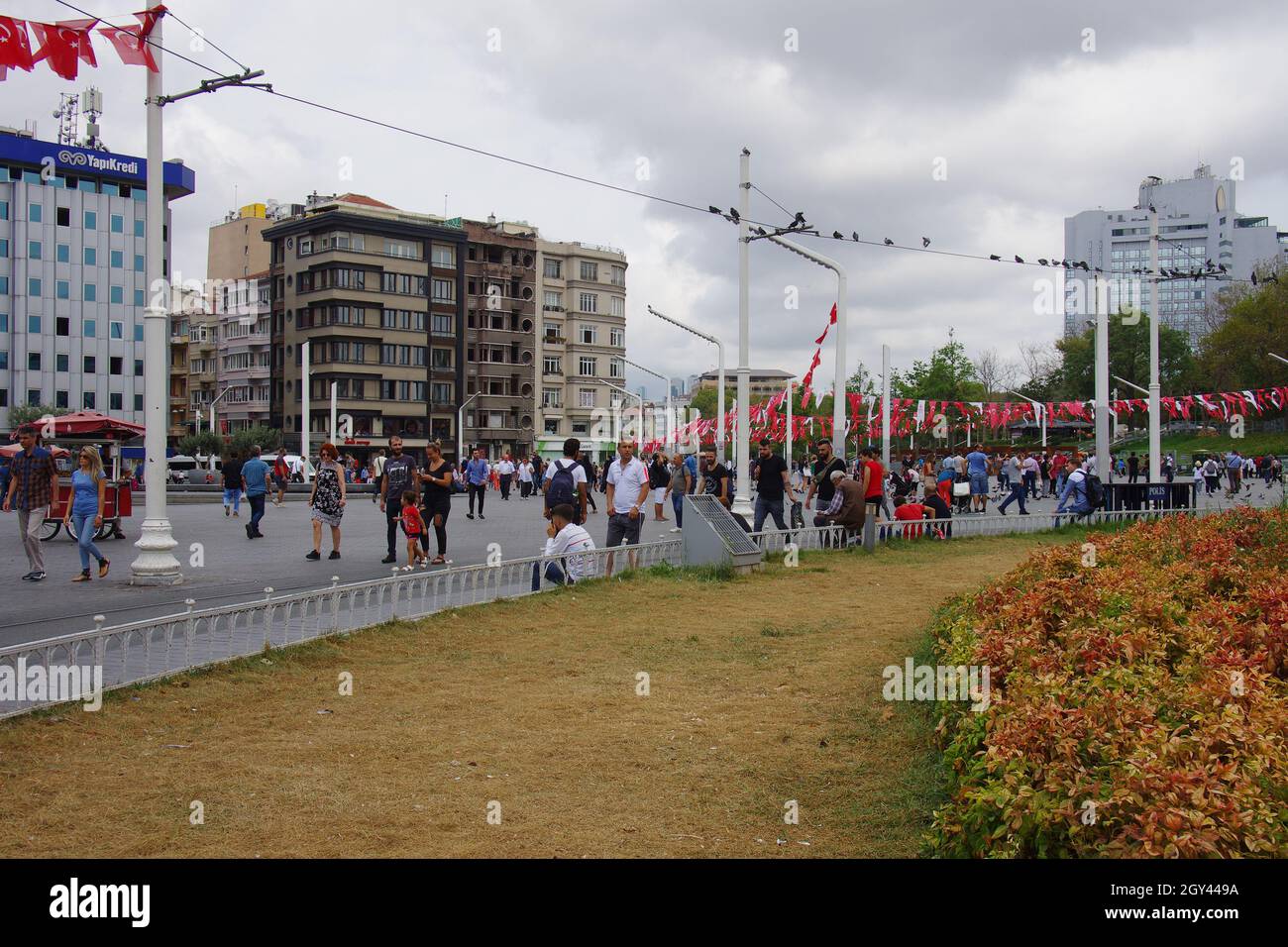 Istanbul - The crowded Taksim square with the new buildings and the numerous red and white flags symbol of Turkey. Stock Photo