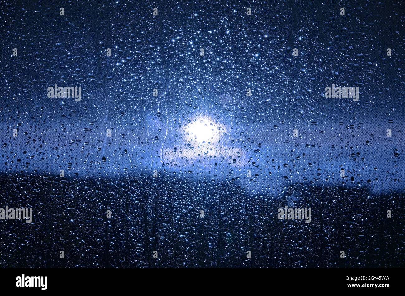 Blue water drops on the window pane. Stock Photo