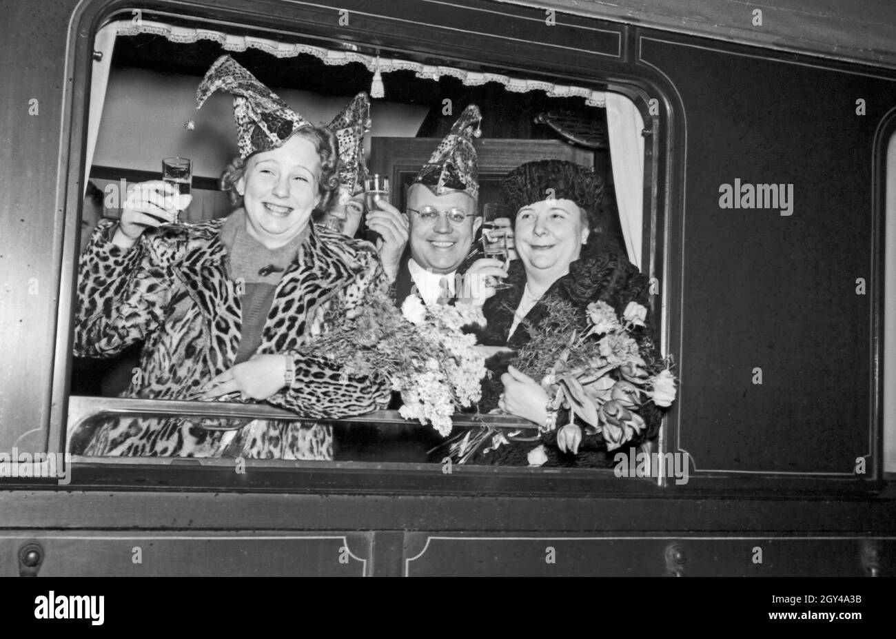 Die Prinzessin der Mainzer Fastnacht 1938, Hildegard Kühne, prostet aus einem Zugfenster dem Fotografen zu. Carnival princess Hildegard Kuehne raising her glass out of the window of a train to the photographer, 1938. Stock Photo