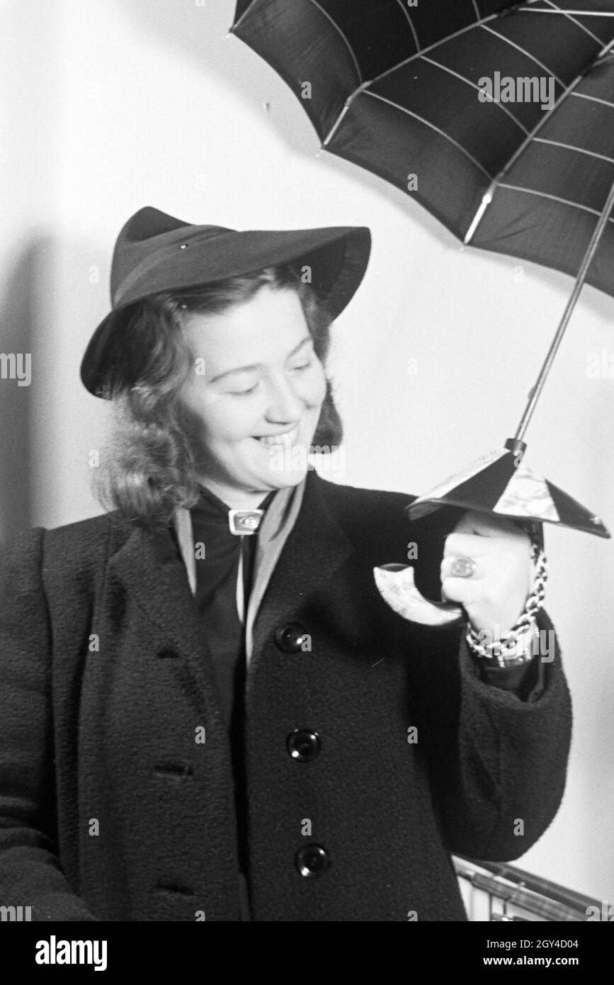 Ein Besucherin der Wiener Modewoche, im Haus der Mode ' Palais Lobkowitz',  bei einer Päsentation von Regenschirmen, Deutschland 1940er Jahre. A visitor of the Vienna fashion week, in the house of fashion ' Palais Lobkowitz', at a presentation of umbrellas, Germany 1940s. Stock Photo