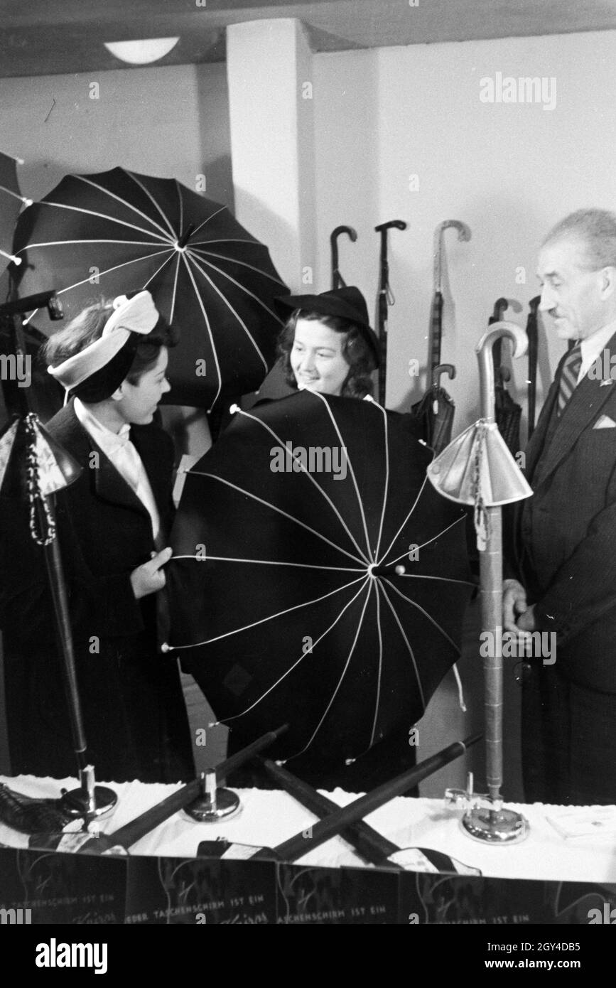 Messebesucher an einem Stand mit Regenschirmen der Firma Knirps, anlässlich  der Wiener Modewoche im Haus der Mode " Palais Lobkowitz", Deutschland  1940er Jahre. Visitors to a fair at a stand with umbrellas