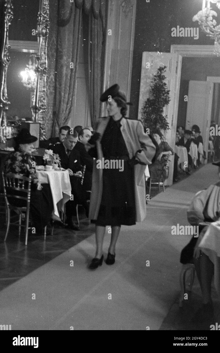 Anlässlich der Modewoche im Haus der Mode " Lobkowitz" präsentiert ein Model auf dem Laufsteeg einen Wintermantel, Deutschland 1940er Jahre. On the of the Vienna fashion week in the