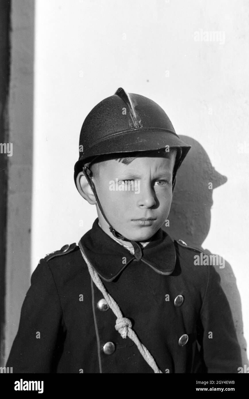 Porträt eines uniformierten Jungen von der Kinderfeuerwehr bei einem Übungseinsatz, Deutschland 1930er Jahre. Portrait of a uniformed boy of the junior firefighters during a training, Germany 1930s. Stock Photo