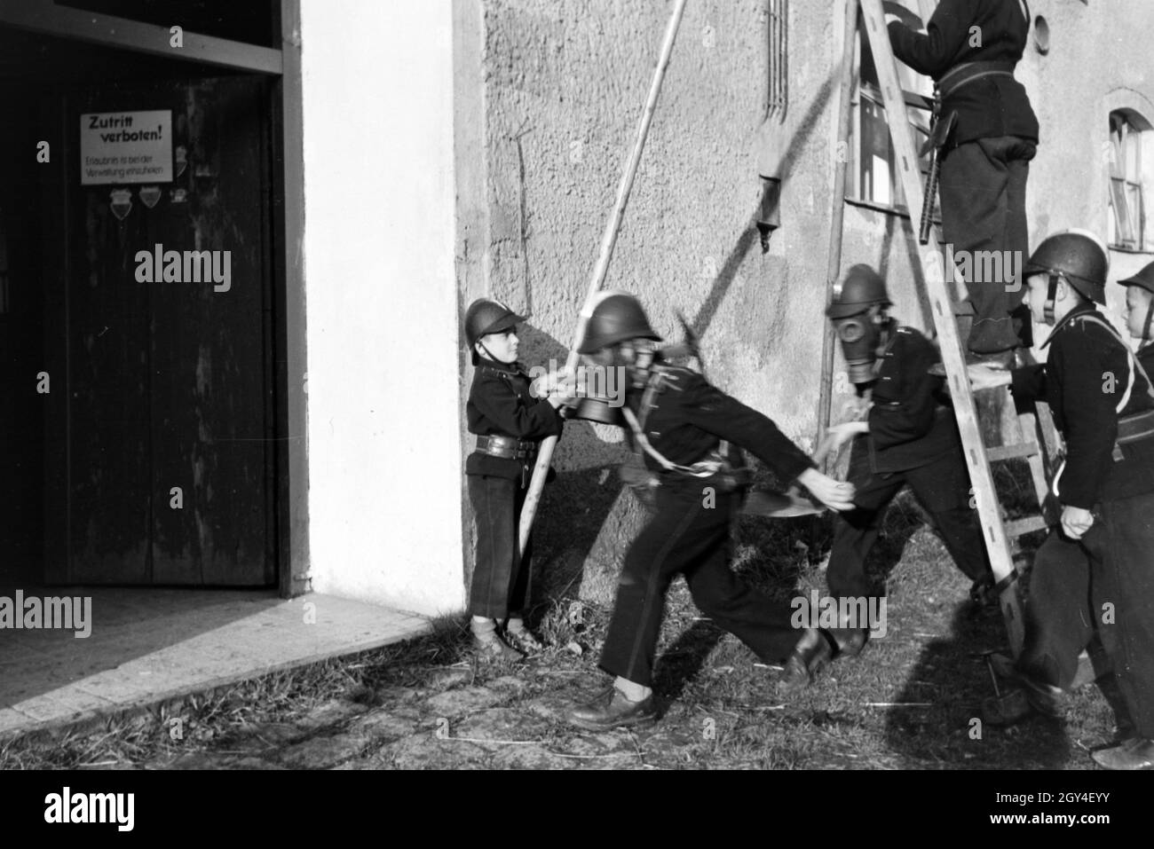 Jungen mit Rauchmasken bei einem Übungseinsatz der Kinderfeuerwehr, Deutschland 1930er Jahre. Boys wearing smoke helmets during a training of the junior firefighters, Germany 1930s. Stock Photo