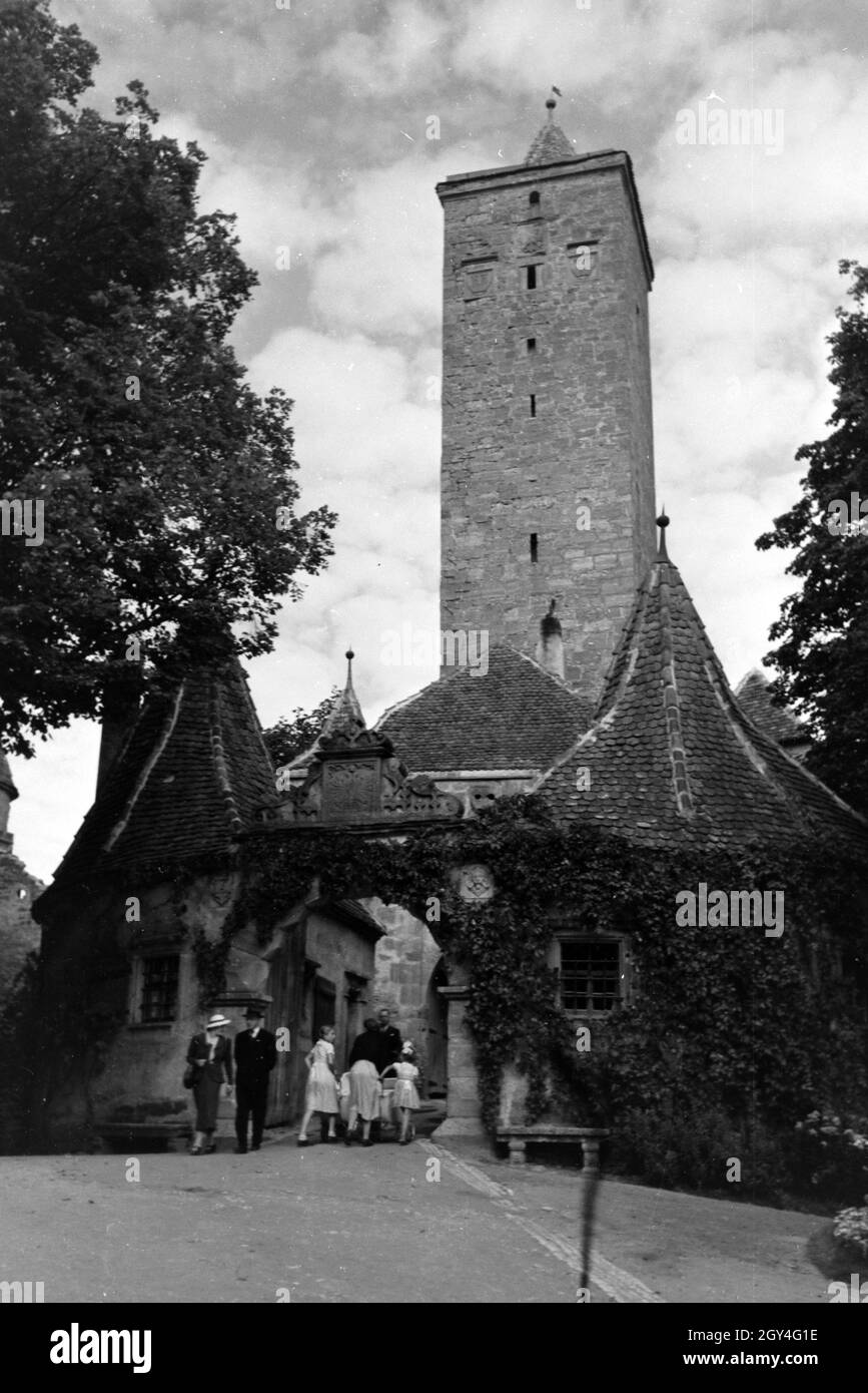 Passanten durchqueren das Burgtor mit dem großem Torturm in Rothenburg ob der Tauber, Deutschland 1930er Jahre. Pedestrians crossing the castle gate with the big tower in Rothenburg ob der Tauber, Germany 1930s. Stock Photo