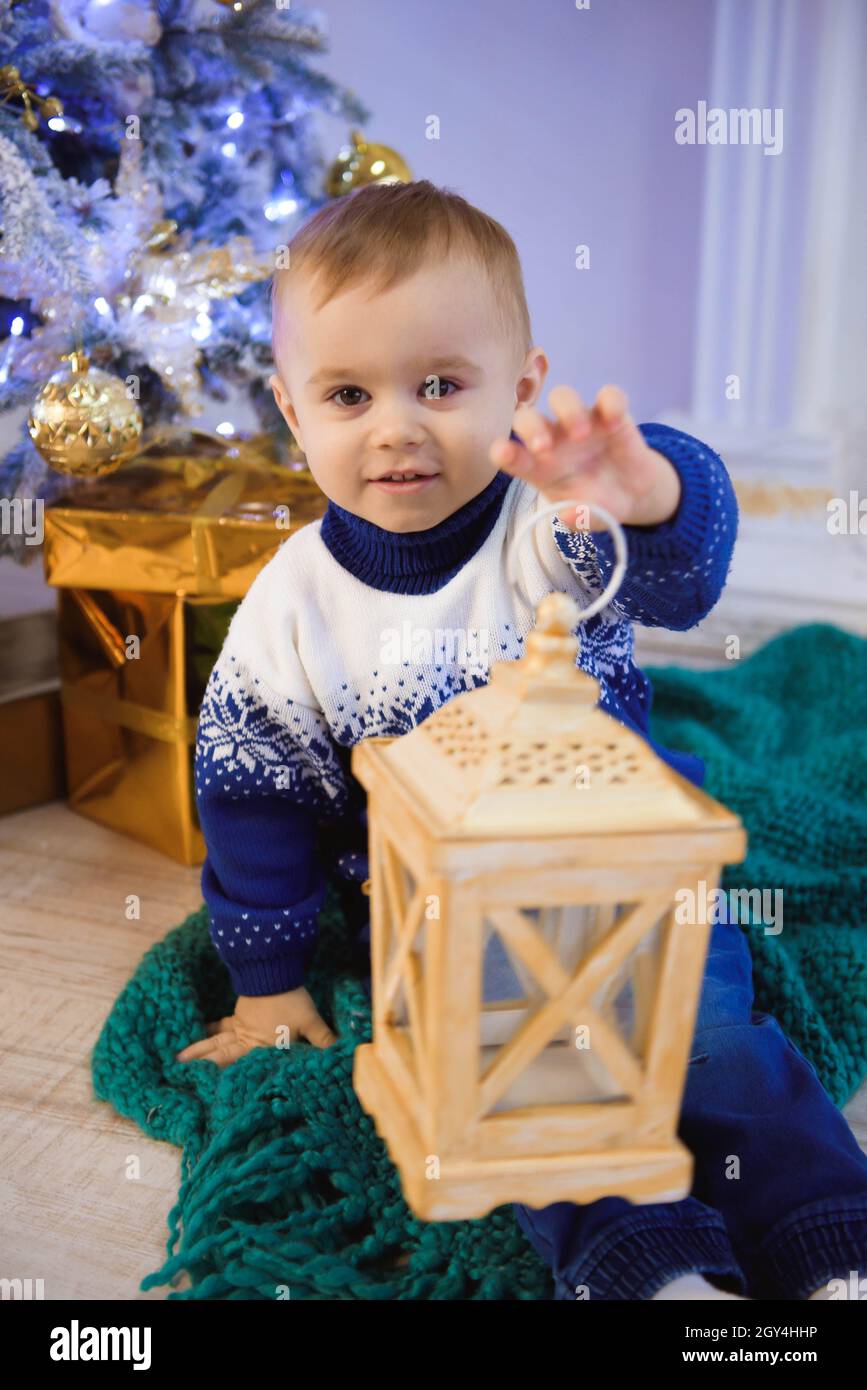 Christmas Child, Kid sitting front of Christmas Tree Stock Photo Alamy