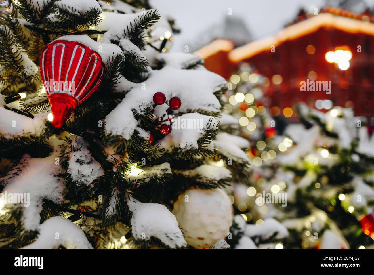 Snow Covered Christmas Tree With Toys And Blurred Bokeh Lights On Festive Background. Merry Christmas And Happy New Year Atmosphere 2022 Stock Photo - Alamy