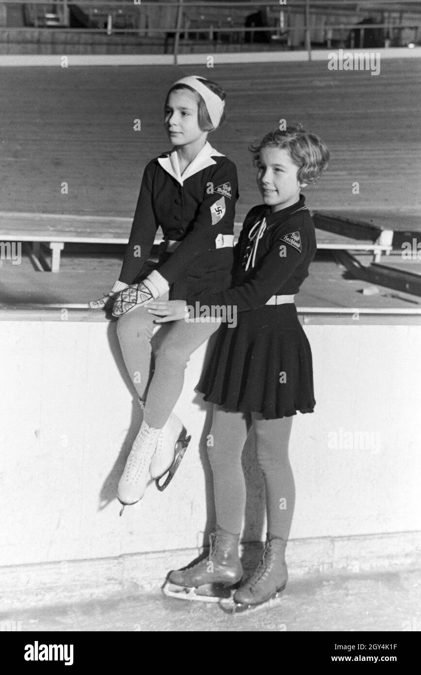 Porträt von zwei BDM Kindereisläuferinnen mit den Hitlerjugend Aufnähern  und dem Hakenkreuzemblem auf der Kleidung, Deutschland 1930er Jahre.  Portrait of two BDM children figureskaters with the Hitler Youth patches  and the swastika