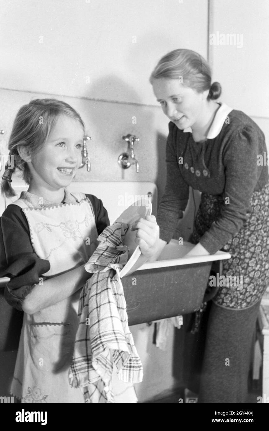 Mitglieder einer kinderreichen Familie bei der Hausarbeit, Deutsches Reich 1930er Jahre. Members of a extended family doing the housework, Germany 1930s. Stock Photo