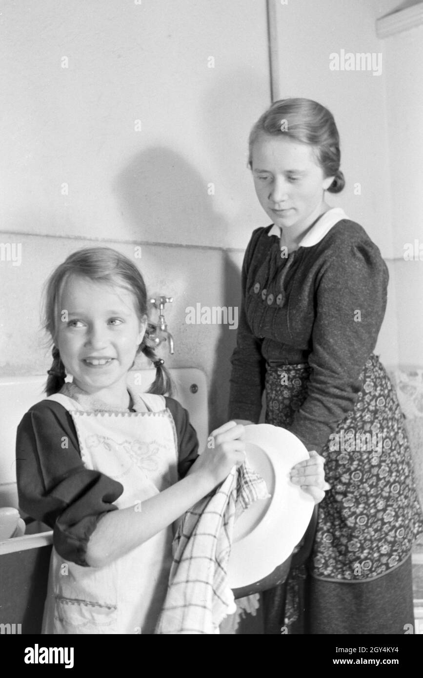 Mitglieder einer kinderreichen Familie bei der Hausarbeit, Deutsches Reich 1930er Jahre. Members of a extended family doing the housework, Germany 1930s. Stock Photo