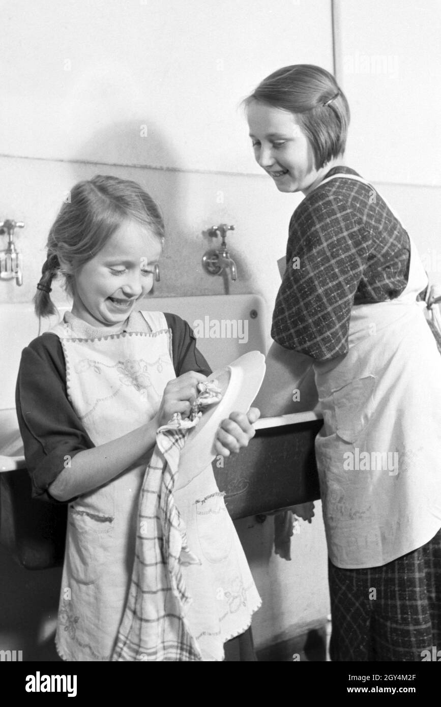 Mitglieder einer kinderreichen Familie bei der Hausarbeit, Deutsches Reich 1930er Jahre. Members of an extended family doing the housework, Germany 1930s. Stock Photo