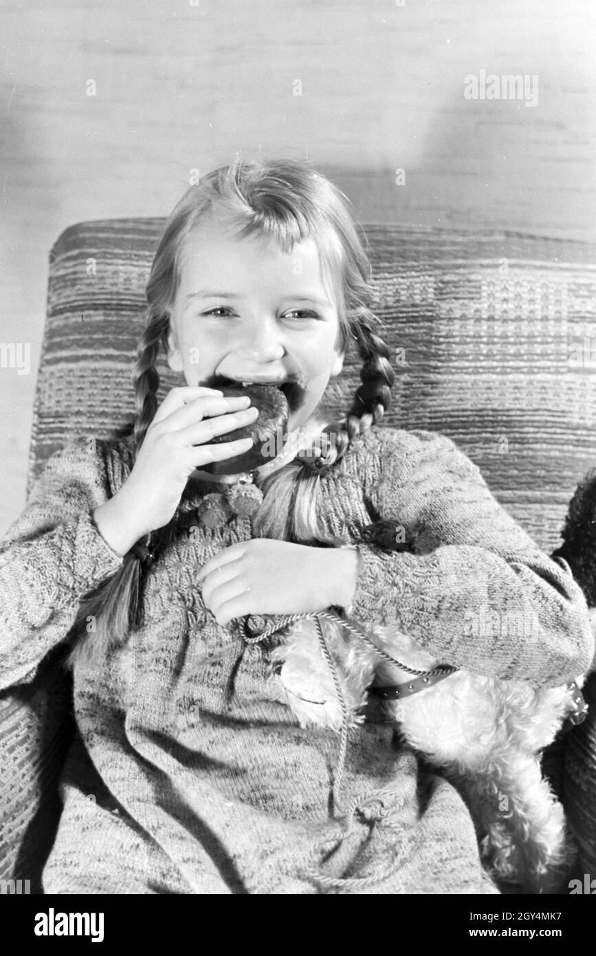 Ein Mädchen isst Liegnitzer Bomben, Deutsches Reich 1930er Jahre. A girl eating Liegnitzer Bomben, Germany 1930s. Stock Photo
