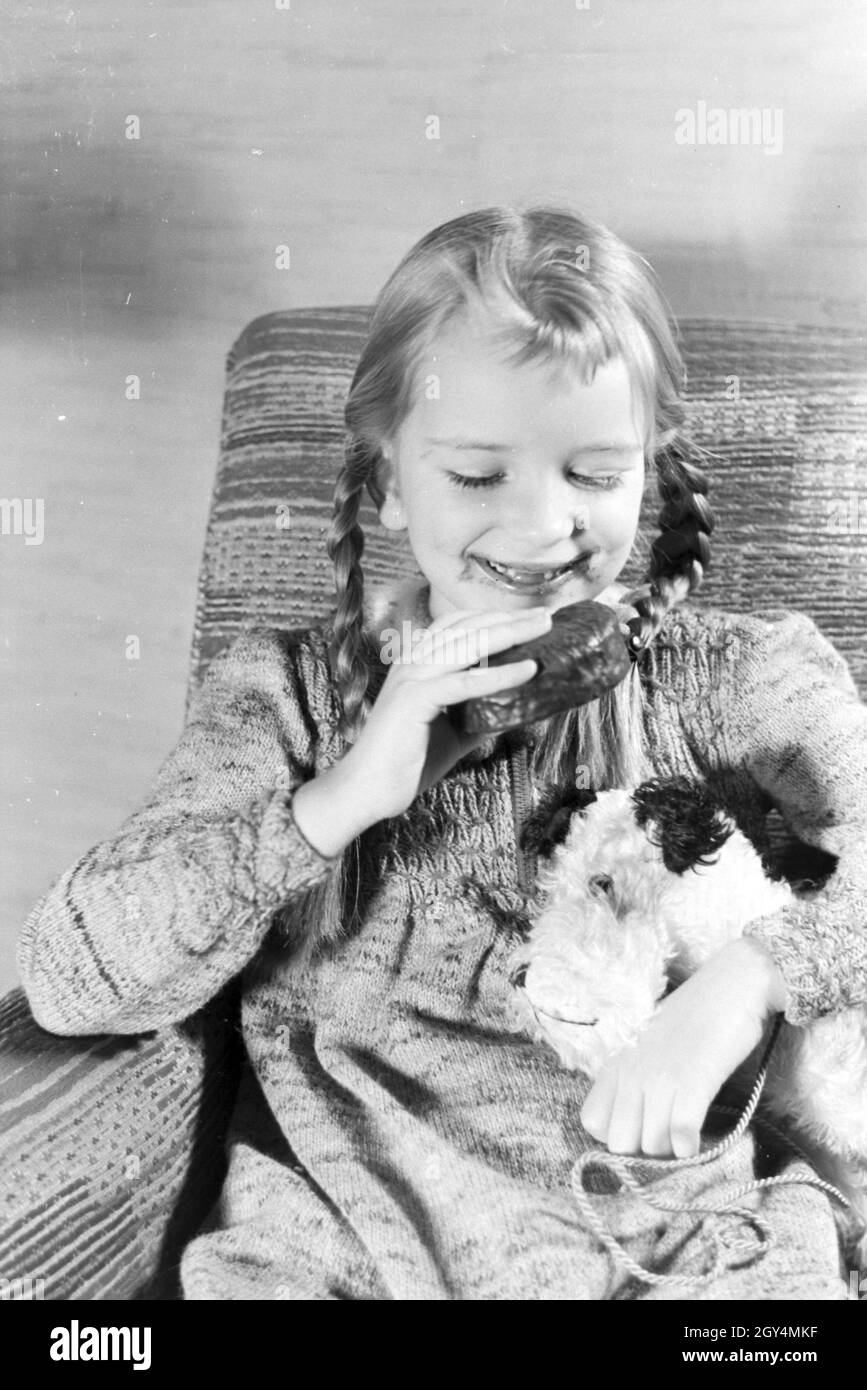 Ein Mädchen isst Liegnitzer Bomben, Deutsches Reich 1930er Jahre. A girl eating Liegnitzer Bomben, Germany 1930s. Stock Photo