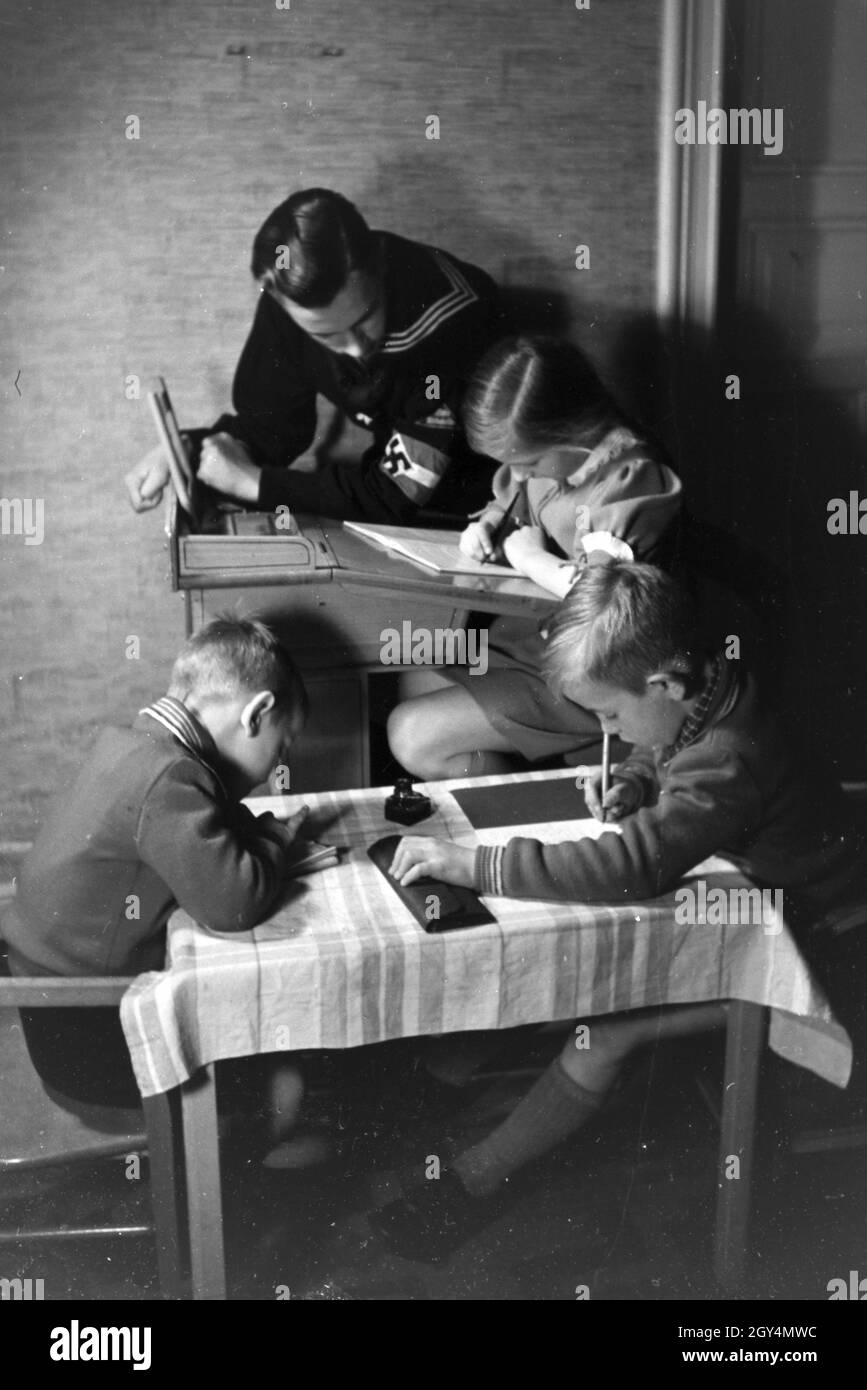 Mitglieder einer kinderreichen Familie helfen sich gegenseitig, Deutsches Reich 1930er Jahre. Members of an extended family helping one another, Germany 1930s. Stock Photo