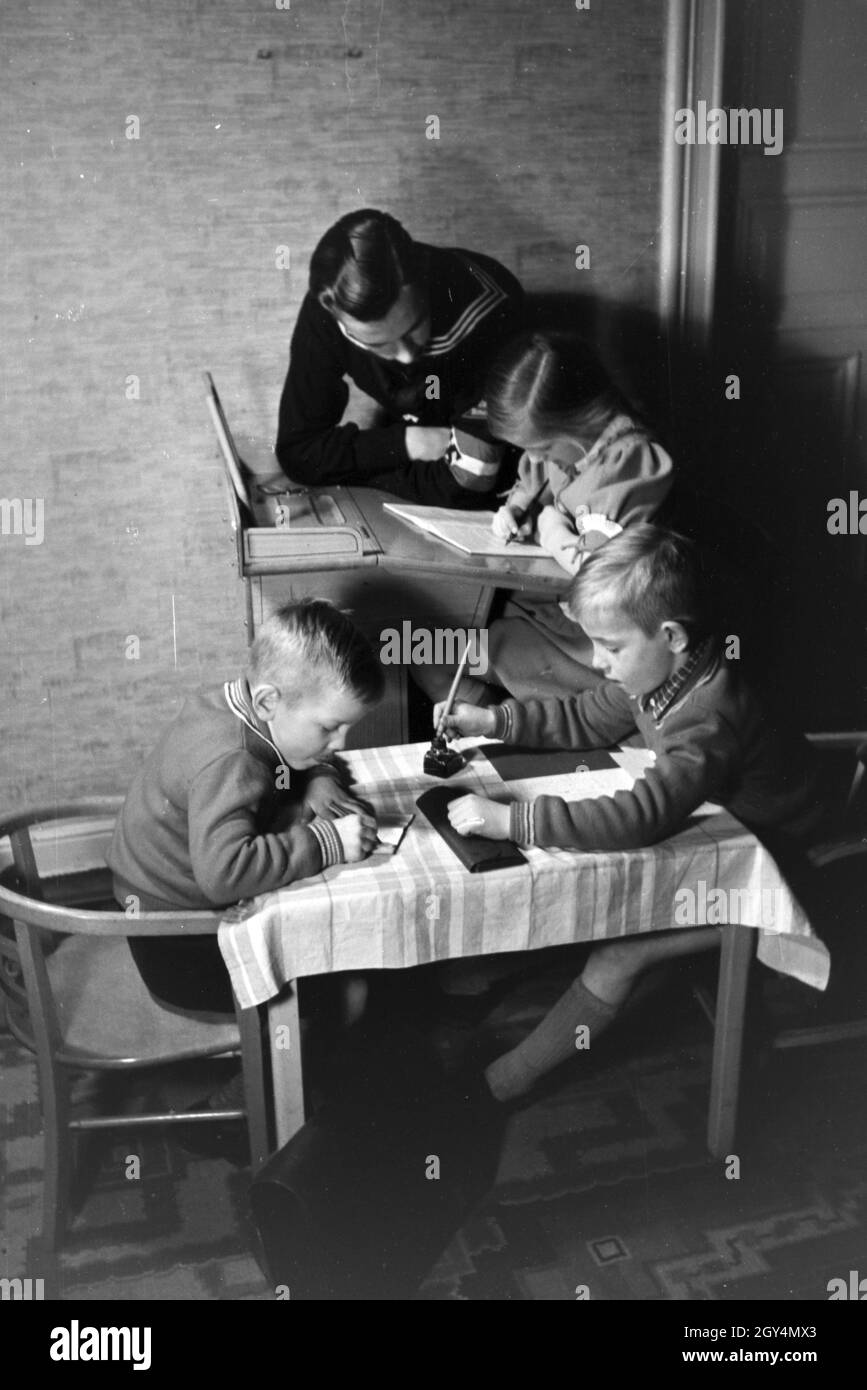 Mitglieder einer kinderreichen Familie helfen sich gegenseitig, Deutsches Reich 1930er Jahre. Members of an extended family helping one another, Germany 1930s. Stock Photo