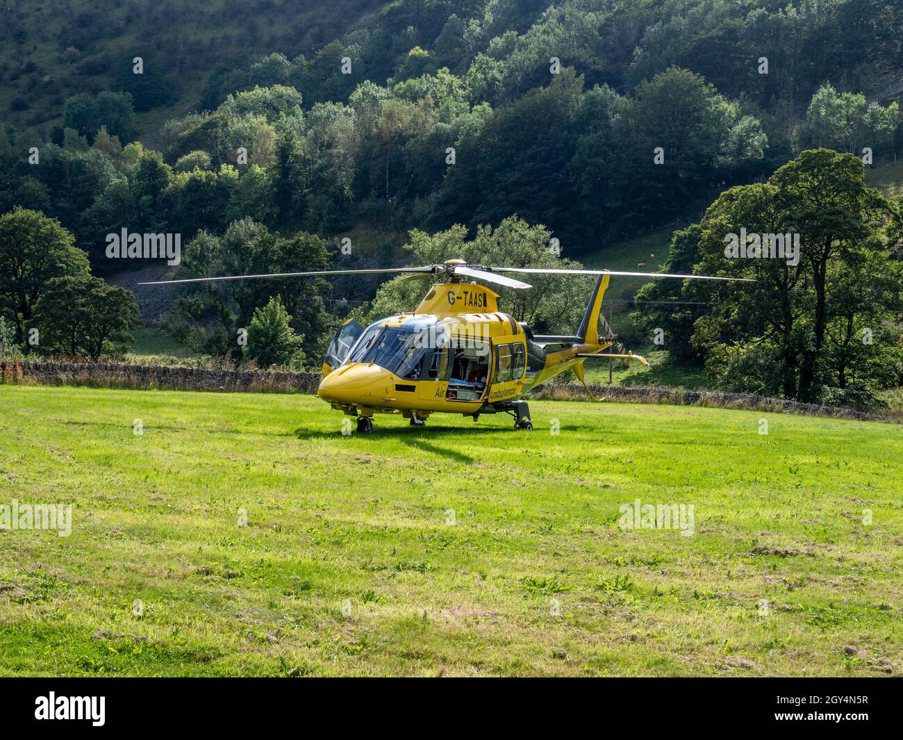 Air ambulance in a field at Cressbrook village, Derbyshire, UK; called out to a serious accident on the nearby Monsal Trail. Stock Photo