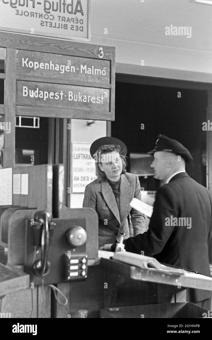Eine Passagierin mit einem Zollbeamten auf dem Flugplatz Tempelhof in Berlin, Deutschland 1930er Jahre. A female passenger with a customs officer at Berlin Tempelhof airport, Germany 1930s. Stock Photo