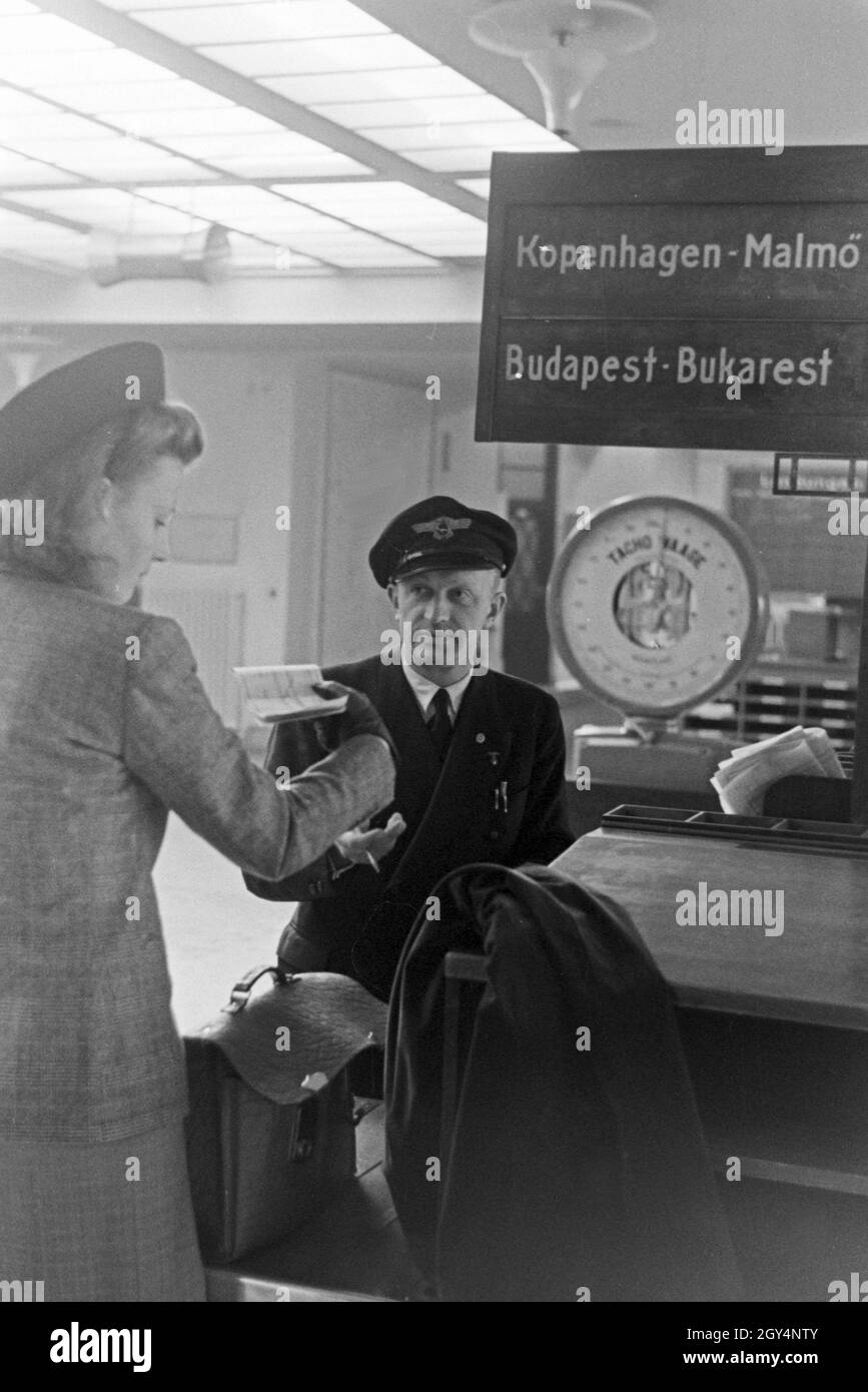 Eine Passagierin mit einem Zollbeamten auf dem Flugplatz Tempelhof in Berlin, Deutschland 1930er Jahre. A female passenger with a customs officer at Berlin Tempelhof airport, Germany 1930s. Stock Photo