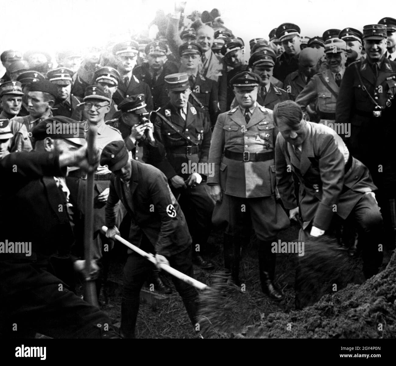 Adolf Hitler digs together with workers with a spade on the construction of the Reichsautobahn. Behind Hitler the Reichsführer NSKK Adolf Hühnlein and Fritz Todt. [automated translation] Stock Photo