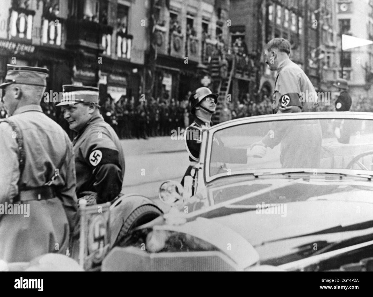 During the Reich Party Congress, Hitler shakes hands with Reichsführer SS Heinrich Himmler wearing a parade helmet M16 from a Mercedes W150 on the main market square in Nuremberg, after the march past by the SS units was completed. On the left are Hermann Göring in party uniform and Viktor Lutze. [automated translation] Stock Photo