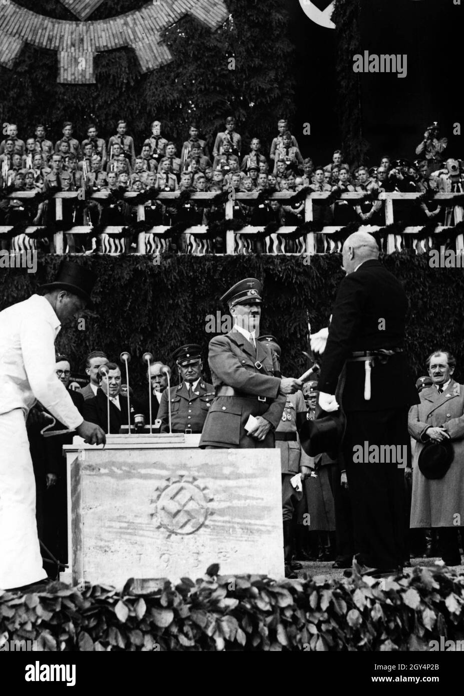 Hitler can be seen in the picture receiving the hammer from the foreman
