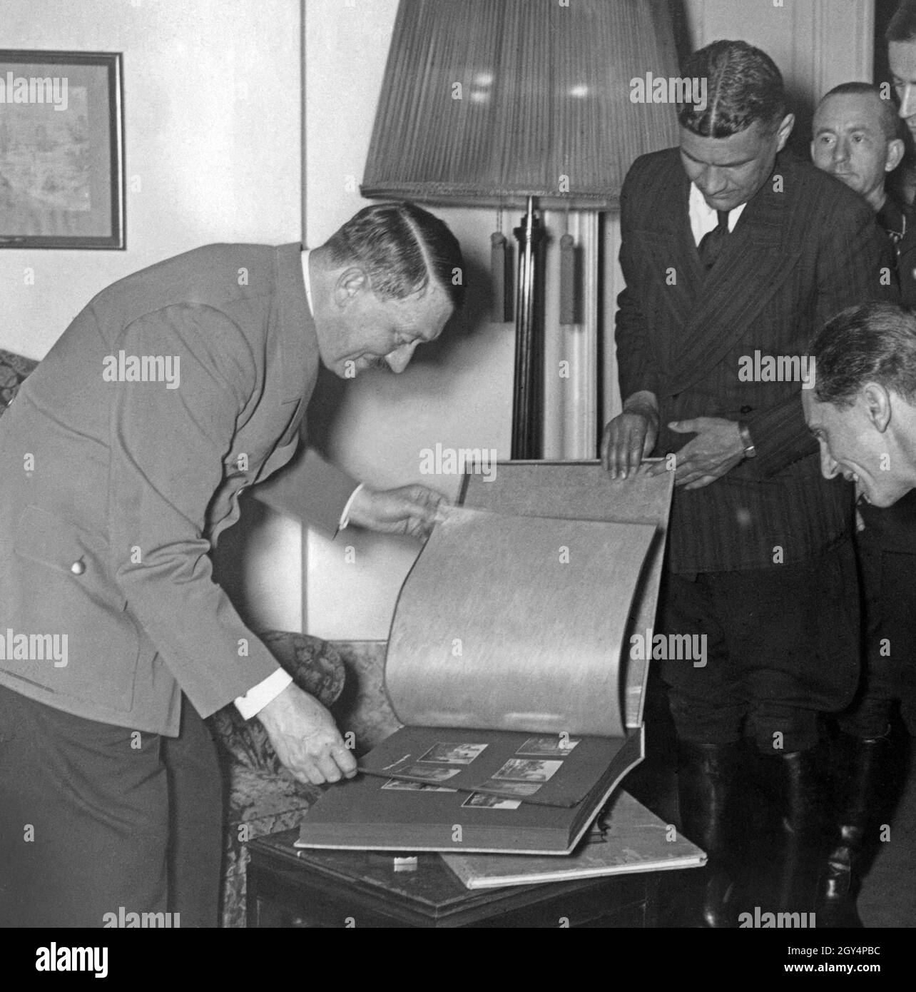 Adolf Hitler is presented with a photo album for his birthday in the Reich Chancellery by (from left) Fritz Wiedemann, Otto Dietrich, Karl Brandt, Max Amann and Joseph Goebbels. [automated translation] Stock Photo