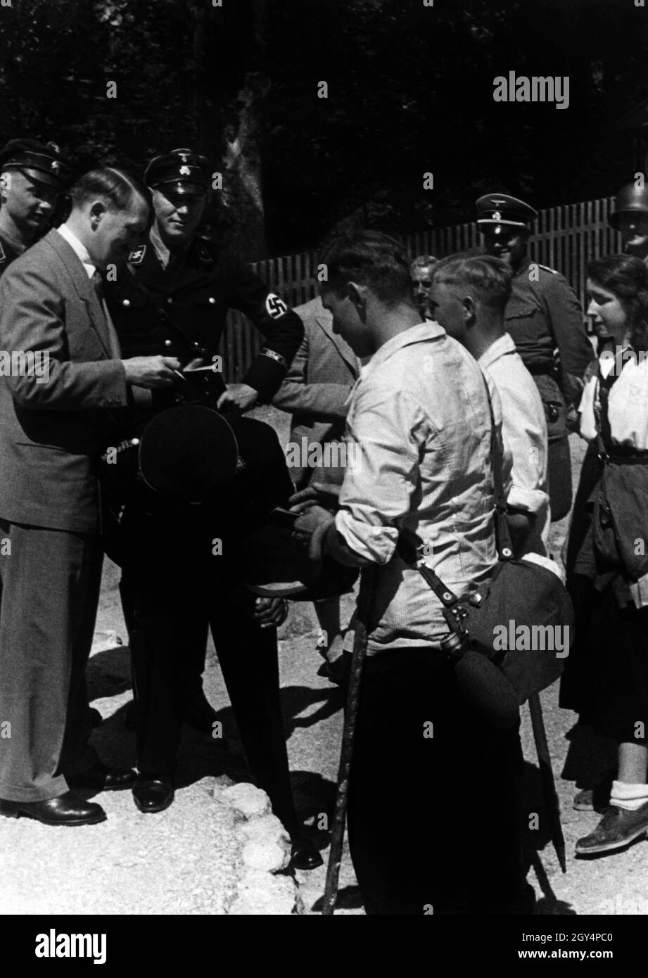 Hitler signs autographs during a holiday in Berchtesgaden. He is constantly accompanied by guards of the SS Führerbegleitkommando. [automated translation] Stock Photo