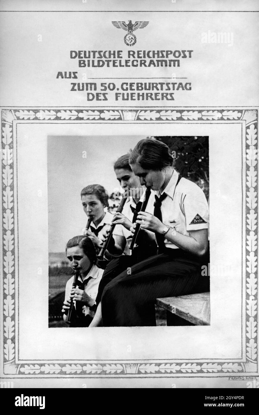 Happy birthday telegram from the German Reichspost on the occasion of Adolf Hitler's birthday in 1938, showing girls playing the flute from the Bund deutscher Mädel des Untergaus or Obergebiets Ost Berlin. The girl on the right wears a visible tradition triangle on her uniform shirt, indicating that she was already a member of the BDM before the Nazis seized power in 1933. [automated translation] Stock Photo