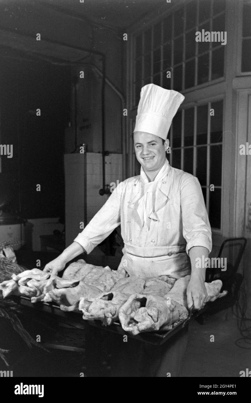 Ein Koch mit frischem Geflügel in der Küche einer Gaststätte, Deutschland 1930er Jahre. A chef with fresh poultry at the kitchen of a restaurant, Germany 1930s. Stock Photo