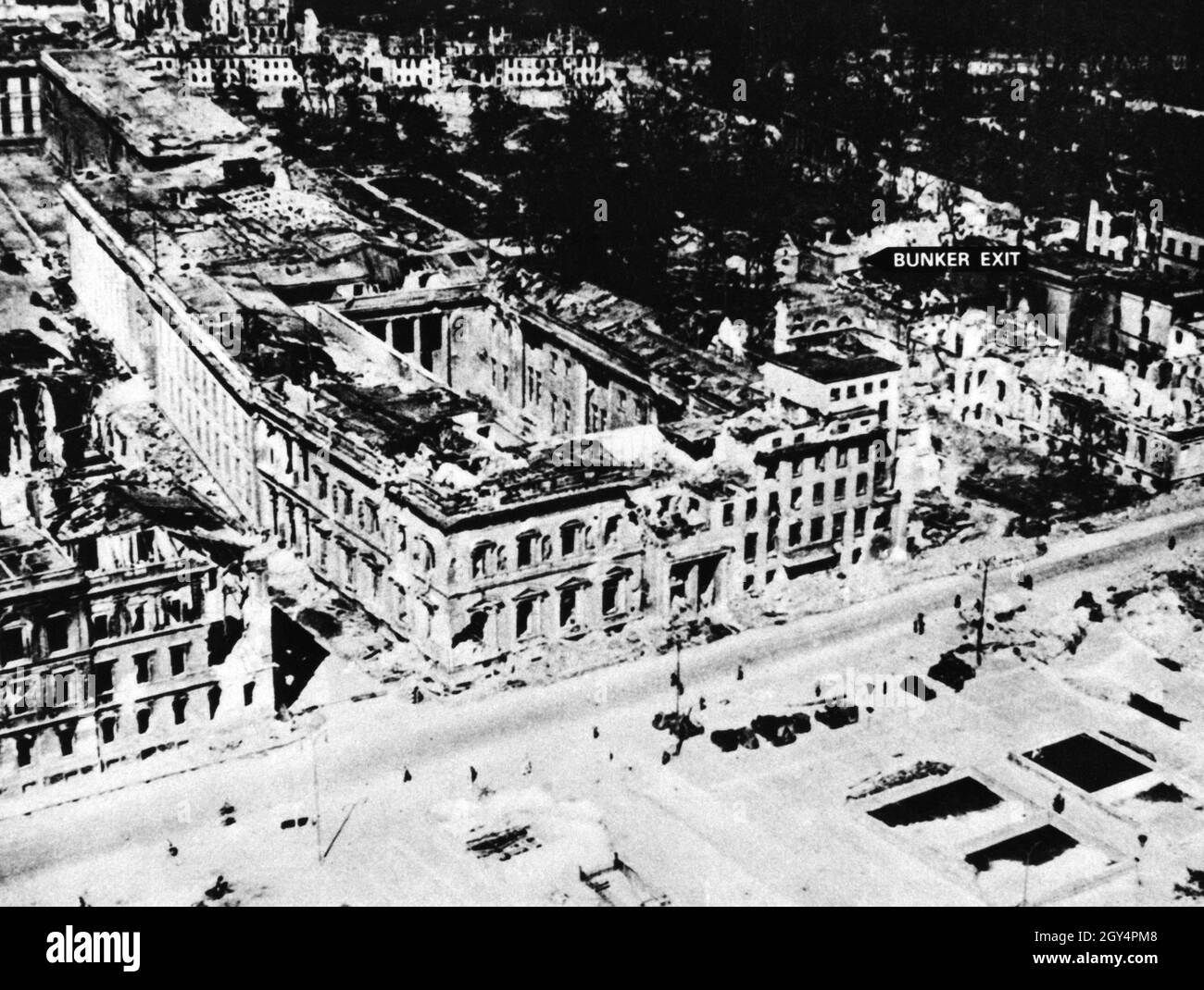 An aerial view of the completely bombed new Reich Chancellery, inaugurated in 1939 but fully completed in 1943. The eastern front in the center of the picture borders on WIlhelm Straße, where the old Reich Chancellery is also located to the right. Along Vossstraße on the left edge of the picture is the entire monumental building of the new Reich Chancellery, which is now a ruin. The picture marks the spot where the bodies of Adolf Hitler and Eva Braun were burned in front of the exit of the Führerbunker. [automated translation] Stock Photo