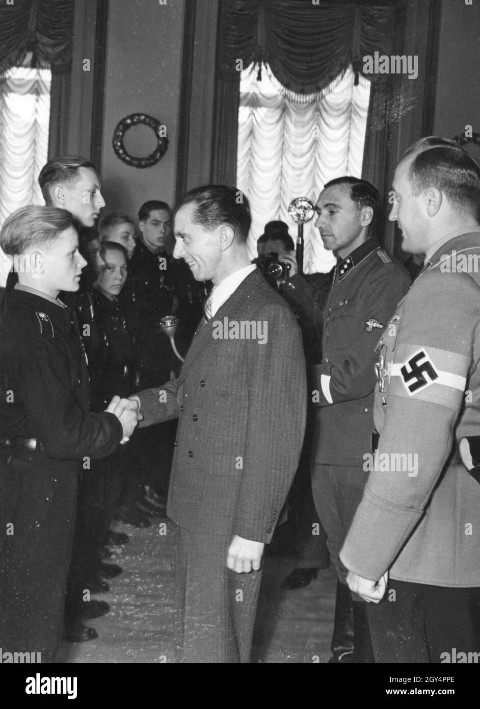 Propaganda Minister Joseph Goebbels (center) receives a number of Hitler Youth from the Rhineland who are awarded the Cross of War Merit or the Iron Cross 2nd Class for their bravery during the air raids on their city. To the right of Goebbels is Reich Youth Leader Axmann. [automated translation] Stock Photo