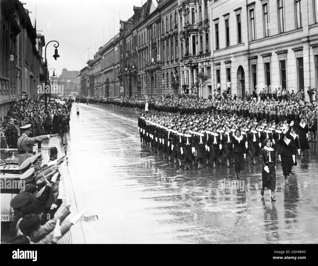 A corps of young fascists from the Opera Nazionale Balilla (youth organization of the Italian fascists) marches through Wilhelmstraße in Berlin-Mitte on June 16, 1937, passing Adolf Hitler (standing in the Mercedes-Benz), people from the NSDAP, SS and Italian fascist organizations. The view goes north in the direction of Unter den Linden. [automated translation] Stock Photo