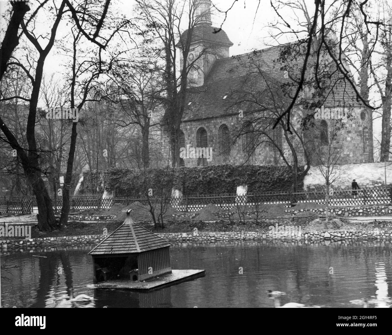 In front of the village church Tempelhof in Berlin lies the Klarensee. On the pond float in 1937 a raft with shelter for ducks and geese. [automated translation] Stock Photo