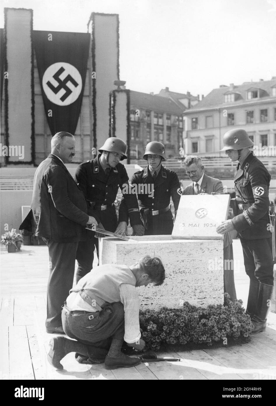 'On May 5, 1934, the foundation stone was laid for the house on Werderscher Markt in Berlin-Mitte, which served as an extension to the Reichsbank. In the morning, six men, including three members of the ''Leibstandarte SS Adolf Hitler'', made the final preparations before the ceremonial laying of the foundation stone with Adolf Hitler, Hjalmar Schacht and other Nazi celebrities was to take place in front of 6000 people in the afternoon. [automated translation]' Stock Photo