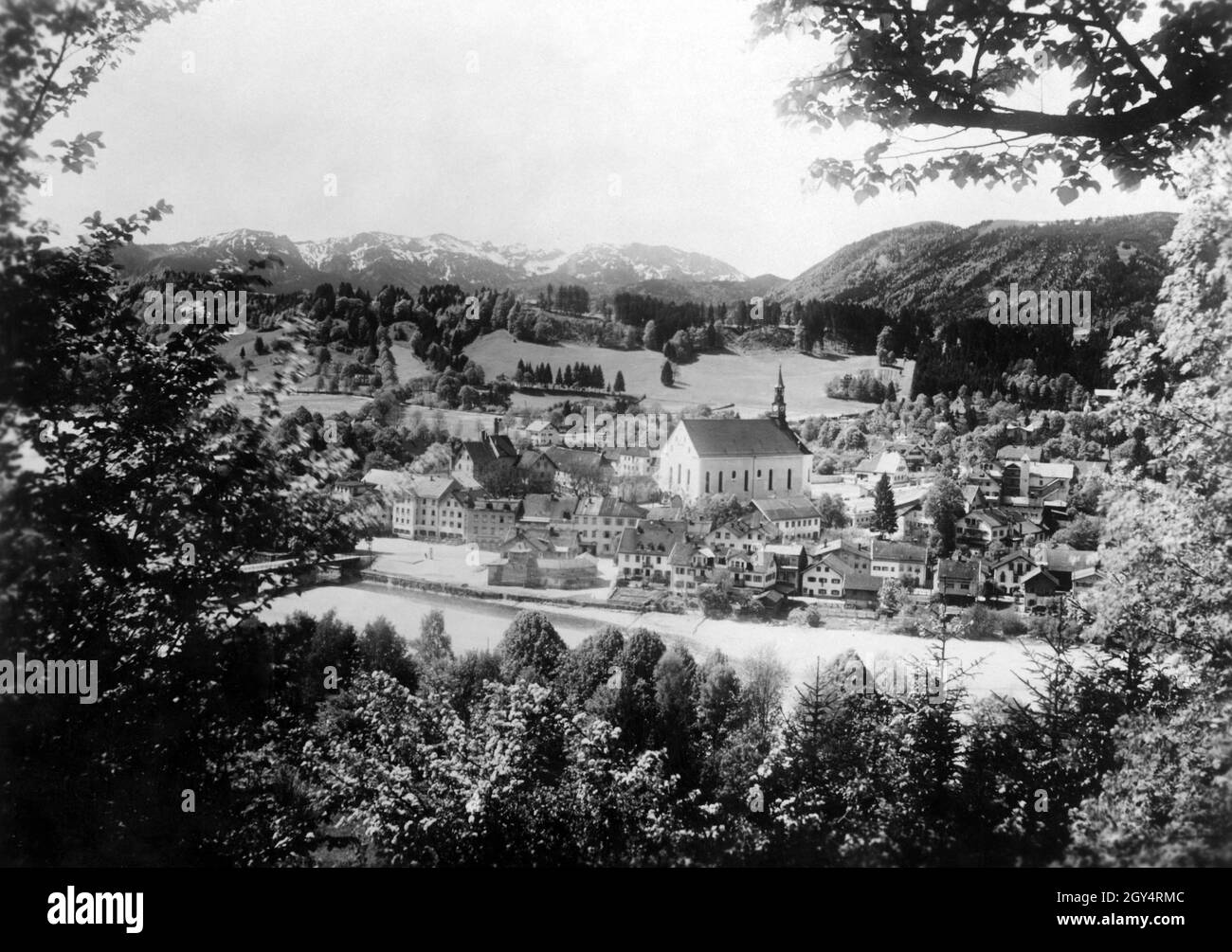 In 1928, the part of Bad Tölz to the west of the Isar with the Franciscan monastery can be seen from the Kalvarienberg. In the background the Alps: on the right Heigelkopf and Blomberg, on the left Benediktenwand, Latschenkopf and Brauneck. [automated translation] Stock Photo