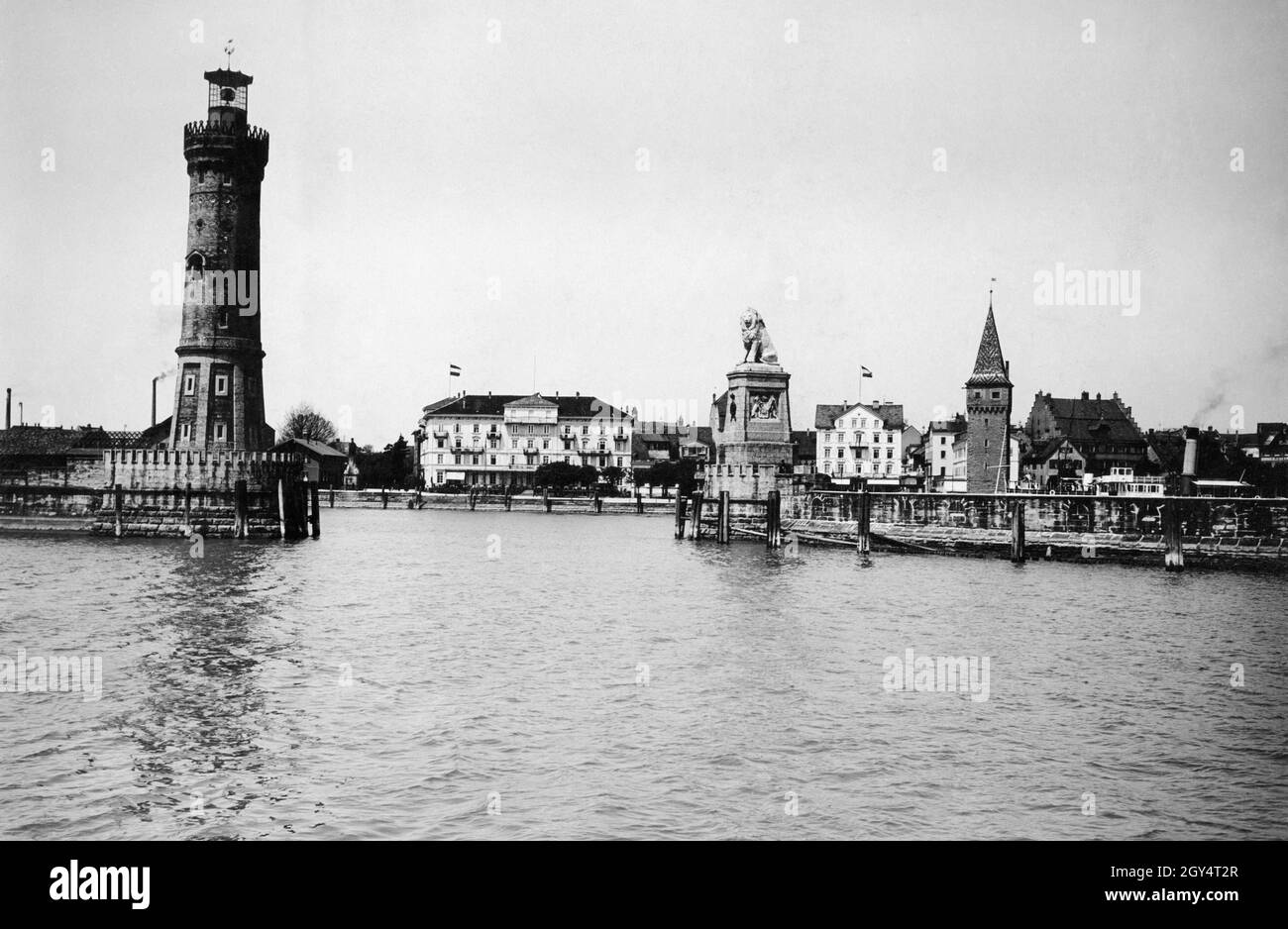 The photograph from 1913 shows the harbour entrance to the port of Lindau in Lake Constance, bordered by the New Lighthouse and the Bavarian Lion. Further to the right is the Mangturm. The building in the middle of the picture is the Hotel Bayerischer Hof, further to the right the Hotel Reutemann can be seen. [automated translation] Stock Photo