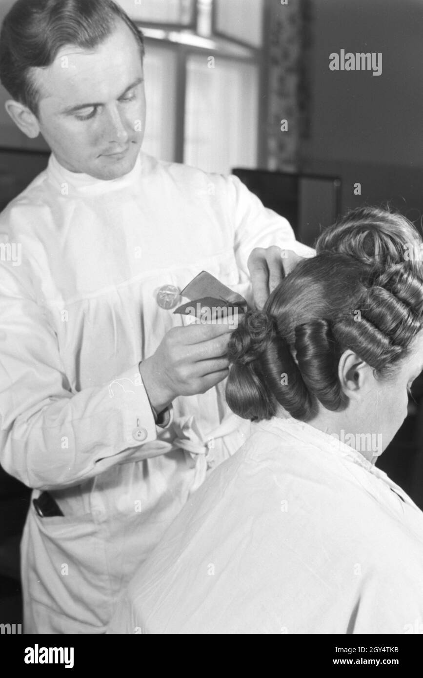 Ein Friseur breitet einer Kundin eine Frisur im Haus der Schönheit,  Deutschland 1930er Jahre. A hairdresser preparing a hairdo at Haus der  Schoenheit beauty salon, Germany 1930s Stock Photo - Alamy